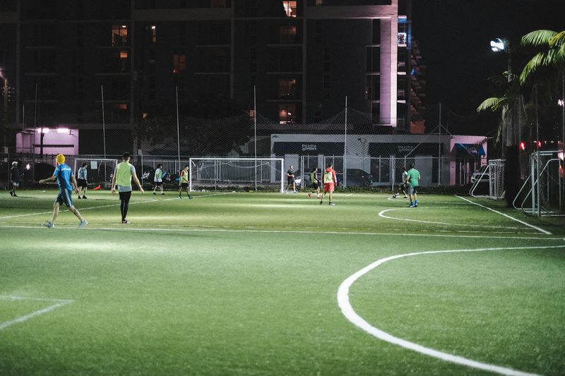 Players warming up on a floodlit pitch at night